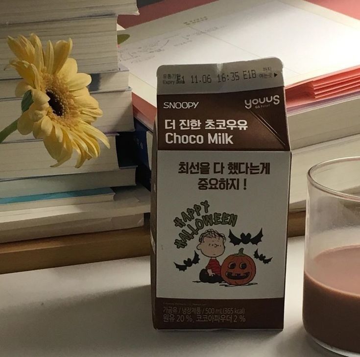 a box of chocolate milk next to a glass of milk with a flower in it