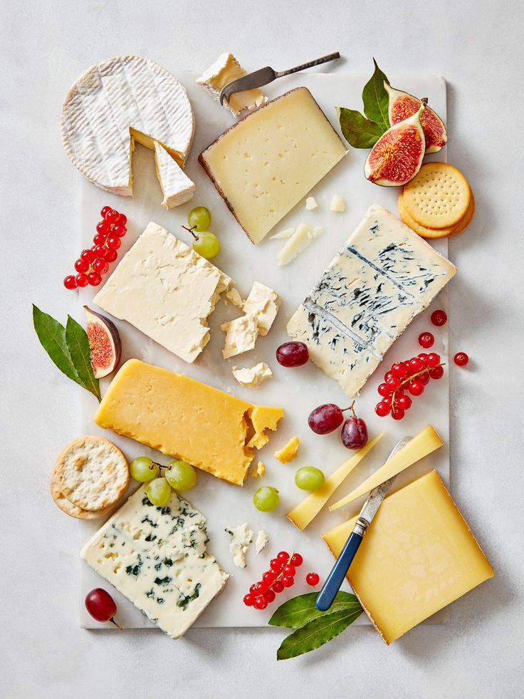 an assortment of cheeses and meats on a cutting board