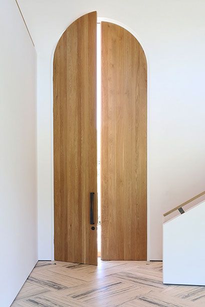 an open wooden door in a white room