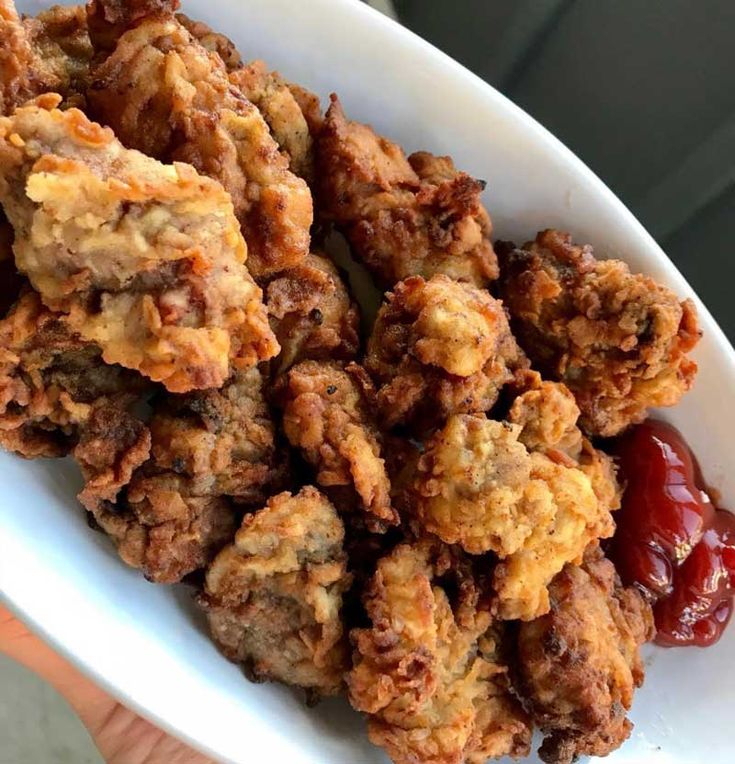 a white bowl filled with fried food on top of a table