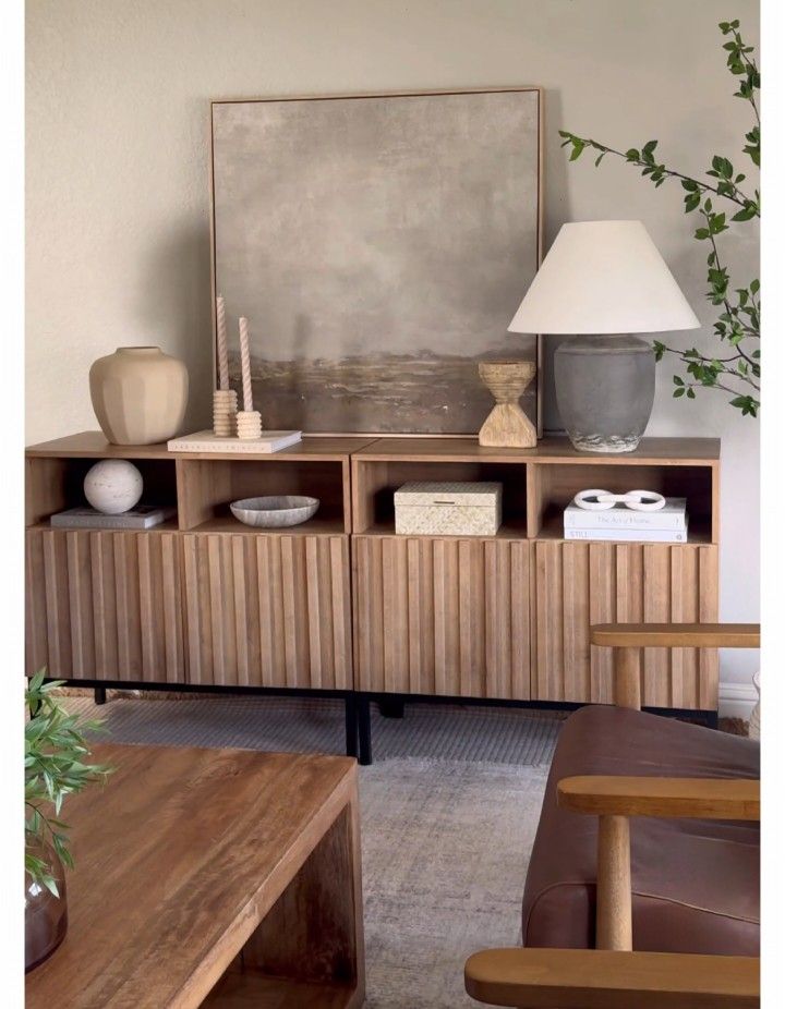 a living room with a couch, table and lamp on it's sideboard