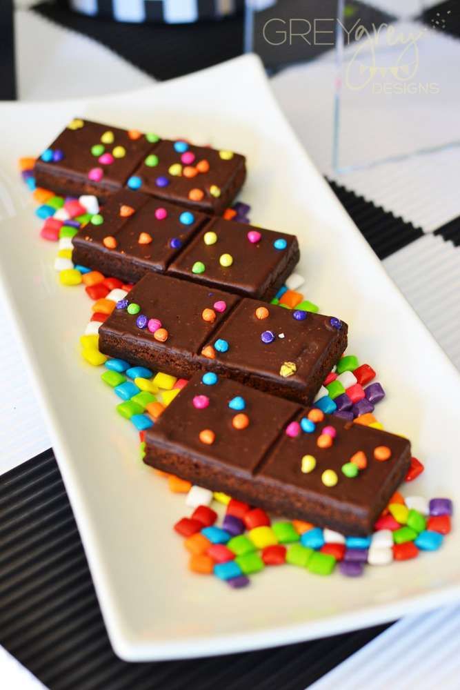 there are many pieces of chocolate with sprinkles on the white square plate