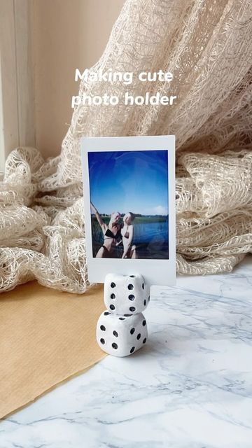 two dices sitting on top of a table next to a photo frame and blanket