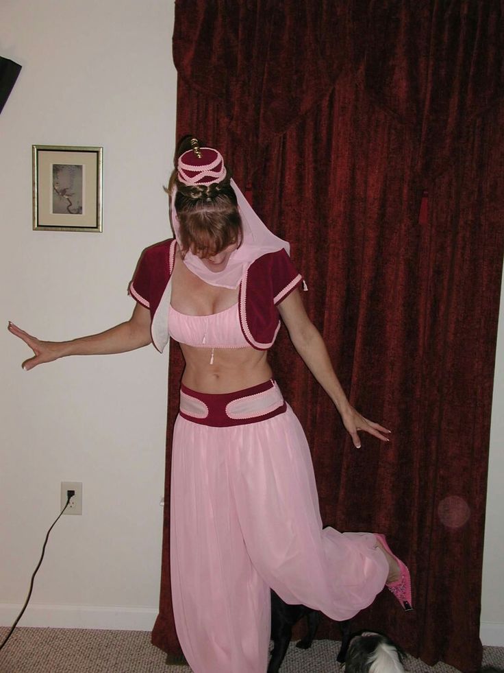 a woman in a pink costume standing next to a cat