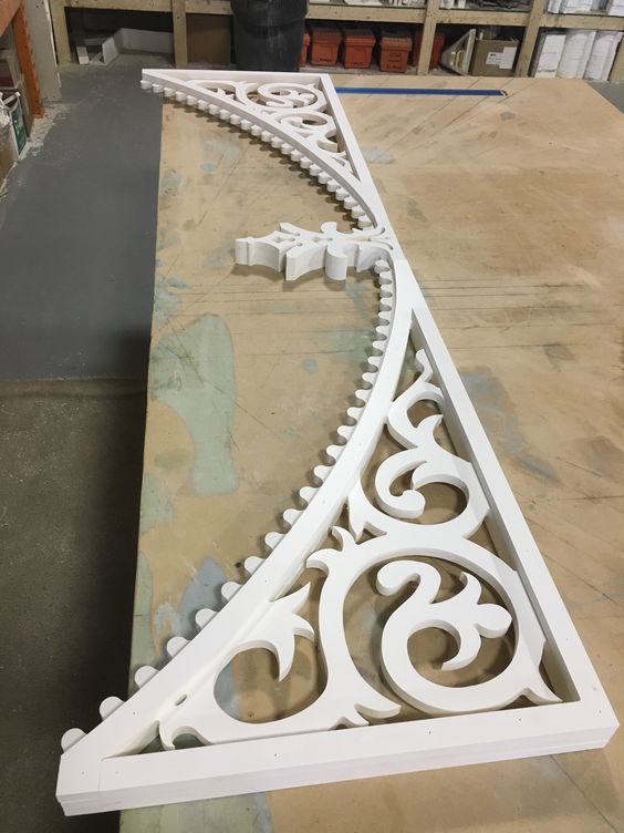 an ornate white iron shelf bracket on a workbench