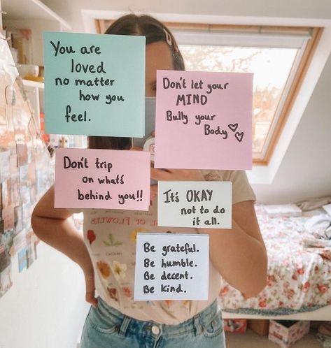 a woman is holding up signs with words written on them that say, you are loved, no matter how you feel