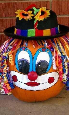 a large pumpkin with a clown face painted on it's face and wearing a hat