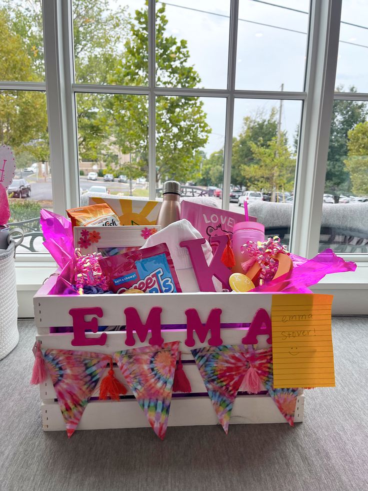 a box filled with personalized items sitting on top of a table next to a window