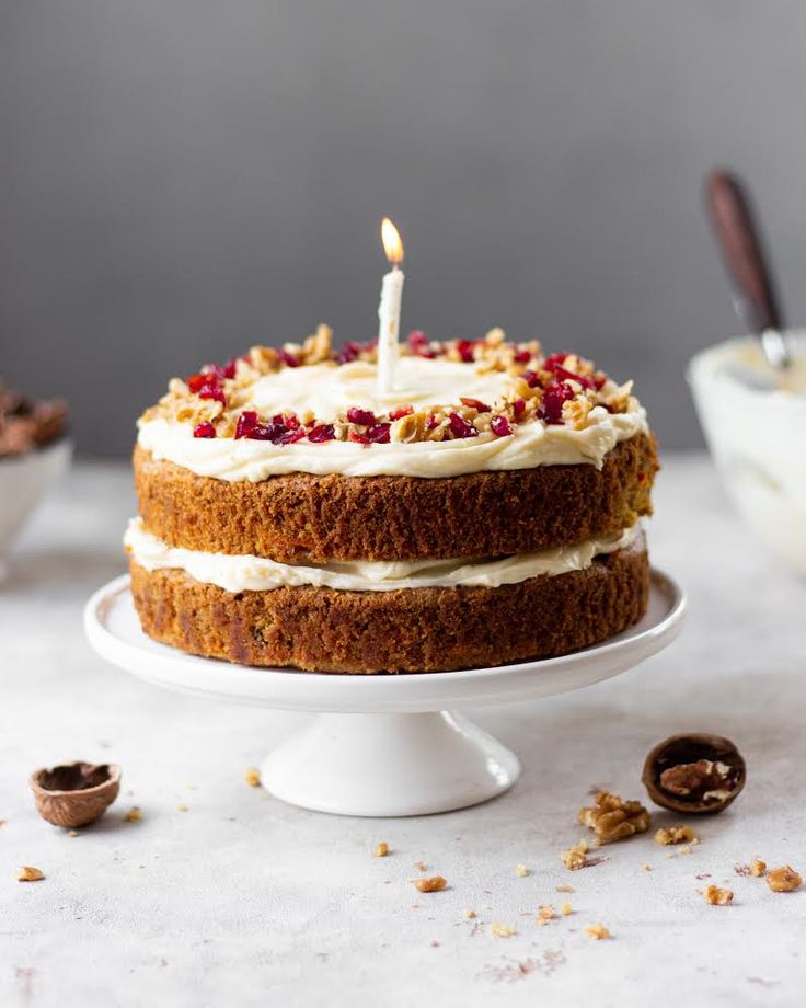 a cake with white frosting and cranberry toppings is on a plate