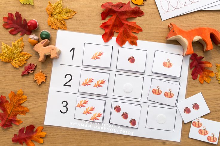 the fall leaves are on the table with numbers and counting mats for them to match