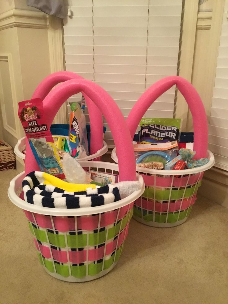 two baskets filled with books and toys sitting on the floor