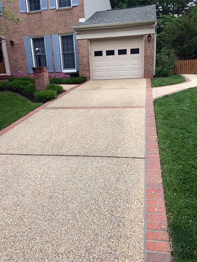 a driveway in front of a brick house