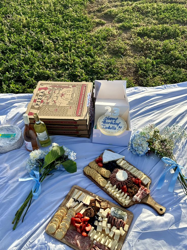 an assortment of cheeses and crackers on a table with blue ribbon around it