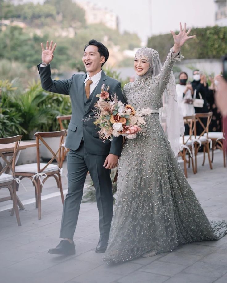 a man and woman are walking down the street with their arms in the air while holding flowers