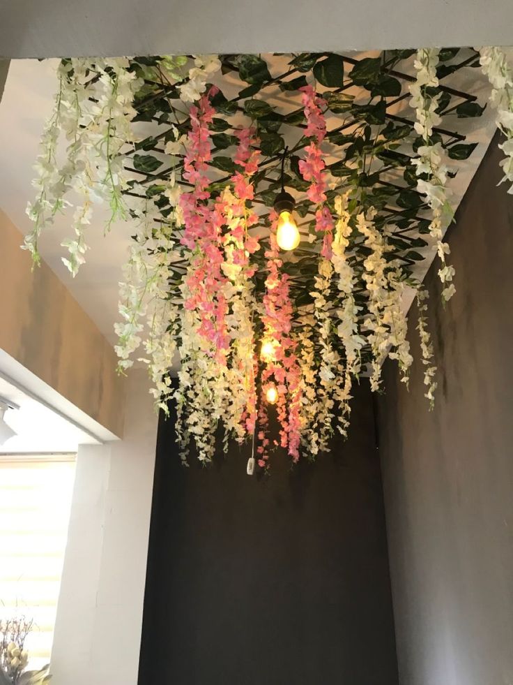 a chandelier with flowers hanging from it's ceiling