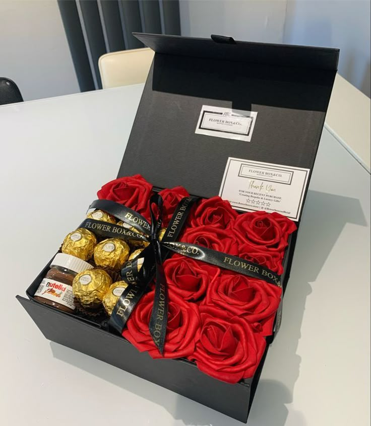 a box filled with roses and chocolates on top of a table