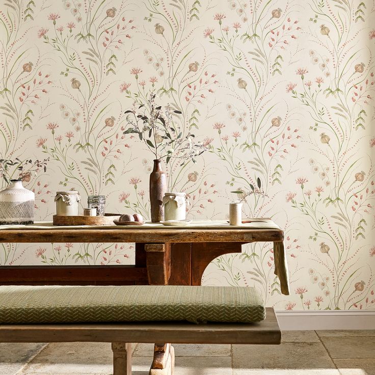 a wooden bench sitting in front of a wallpapered dining room with flowers on it