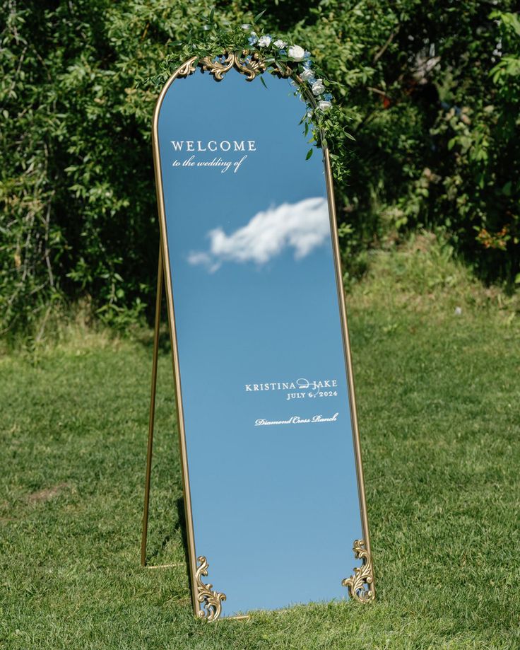 a large mirror sitting on top of a lush green field