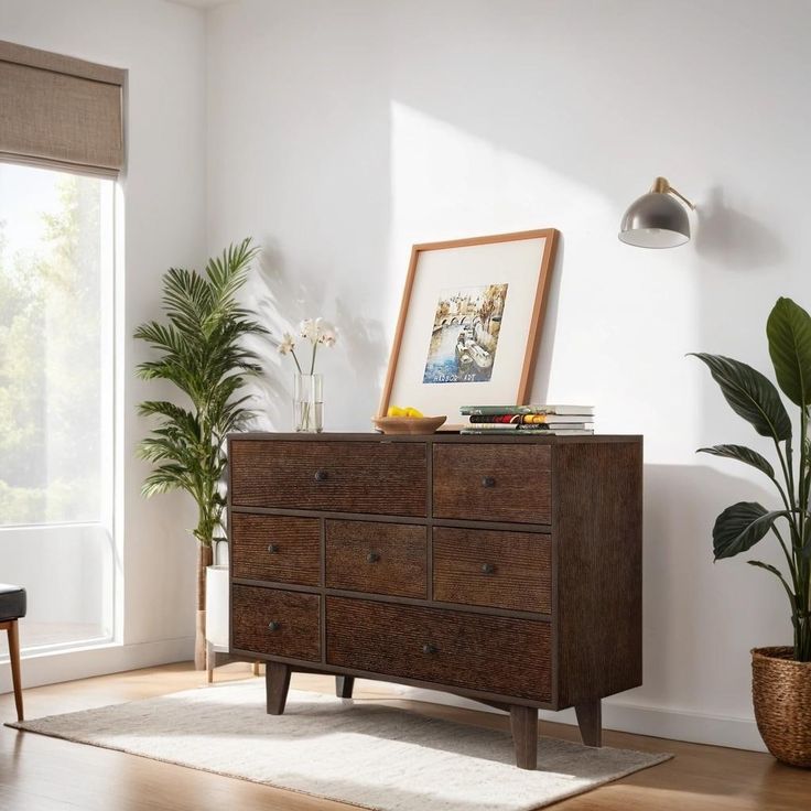 a living room scene with focus on the dresser and potted plant in the corner