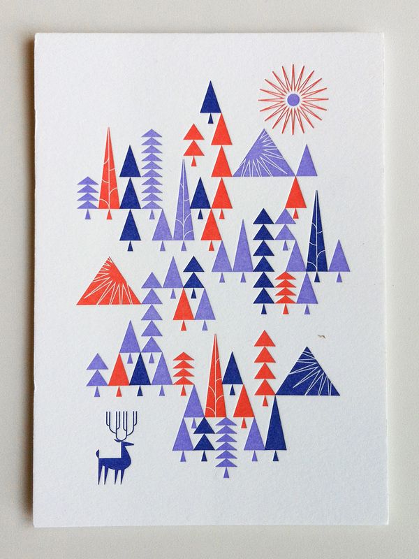 a card with trees, mountains and deer on the front in red, purple, and blue