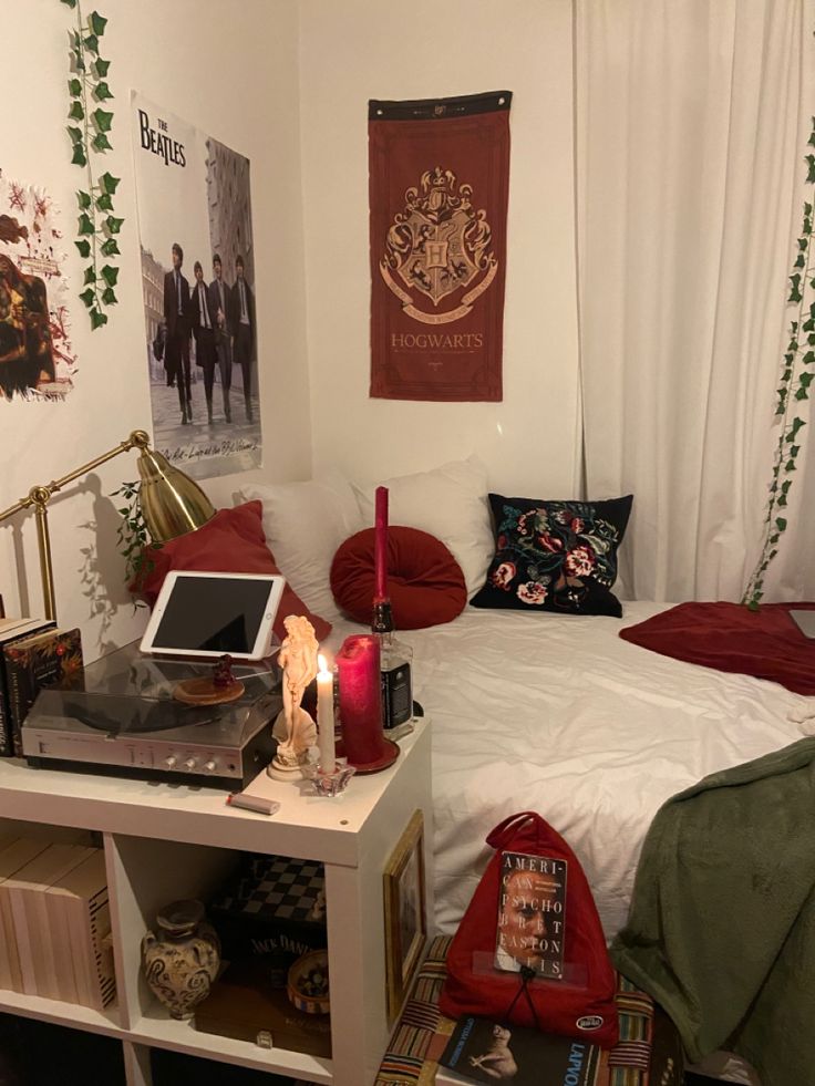 a room with a bed, desk and pictures on the wall above it is decorated with harry potter decorations