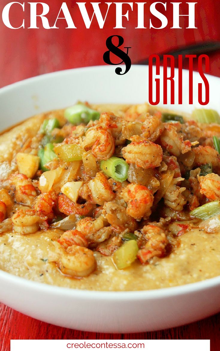 a white bowl filled with shrimp and grits on top of a red wooden table