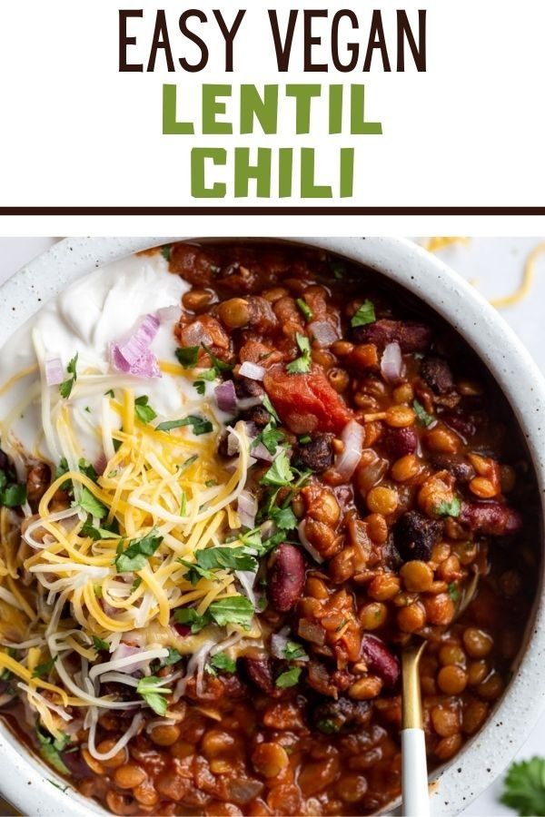 a white bowl filled with beans, cheese and cilantro on top of a table