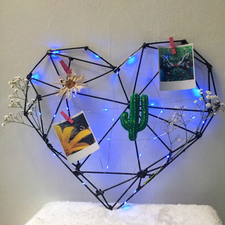 a heart shaped sculpture with pictures on it and lights in the shape of a cactus