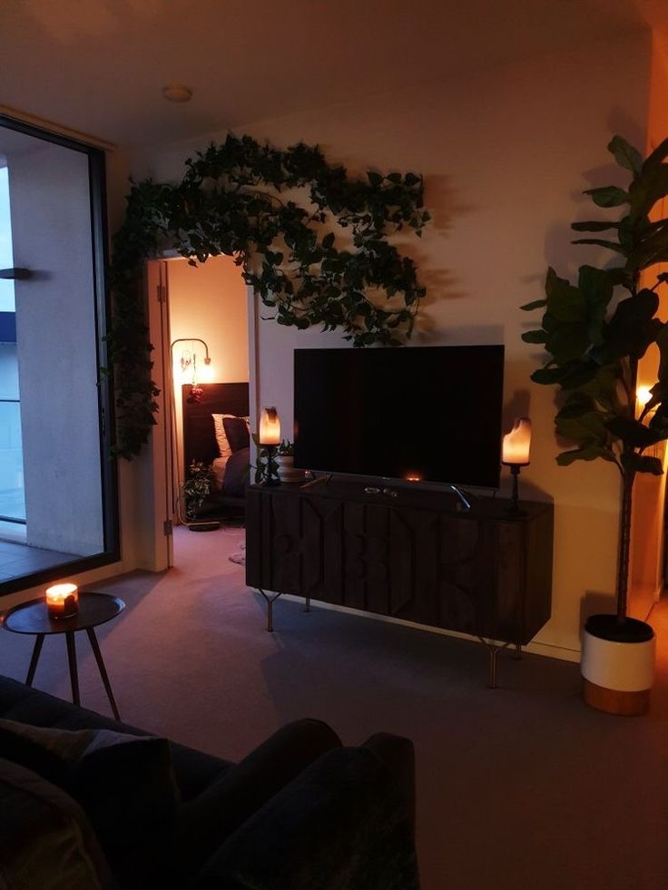 a living room filled with furniture and a flat screen tv sitting on top of a wooden cabinet