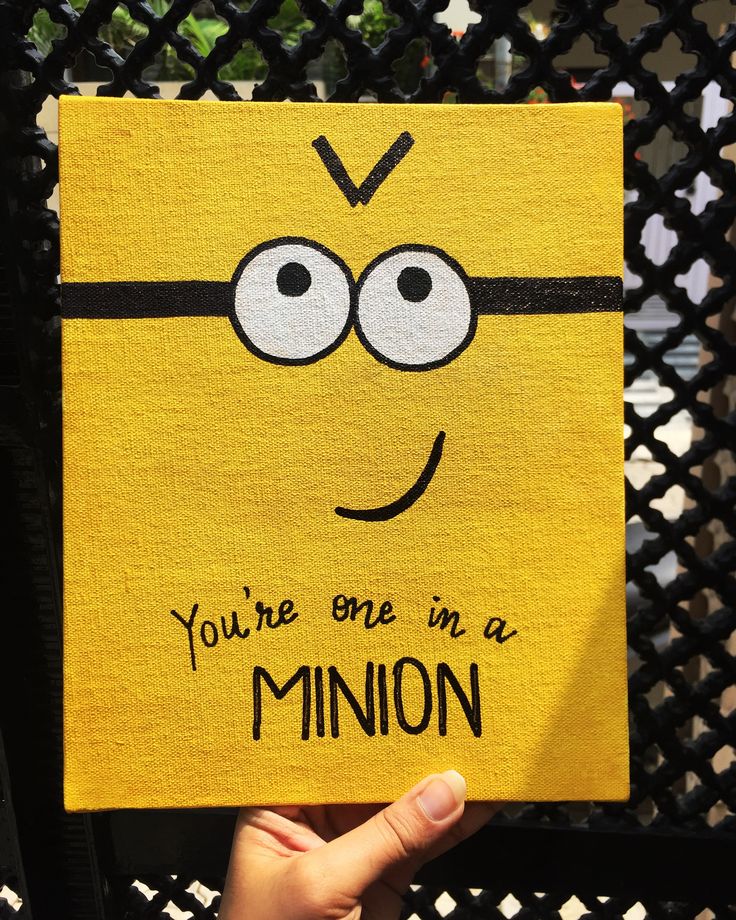 someone is holding up a yellow piece of paper with a drawing of a minion on it