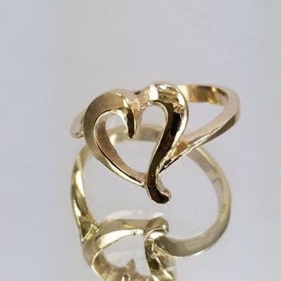 14k Gold Ring with a heart in the center. For only $289.00. Purchase comes with a gift box included. Ring size is adjustable, please note the size in the personalization section of checkout. Adjustable Gold Heart Ring In Sterling Silver, Adjustable Gold Sterling Silver Heart Ring, Heart Shaped Open Ring With Polished Finish For Wedding, Wedding Heart Ring With Polished Open Ring Finish, Wedding Heart Ring With Polished Open Design, 14k Stamped Open Heart Jewelry For Anniversary, 14k Open Heart Jewelry For Anniversary, Adjustable Open Heart Ring For Anniversary, Elegant Double Heart Rings For Formal Occasions