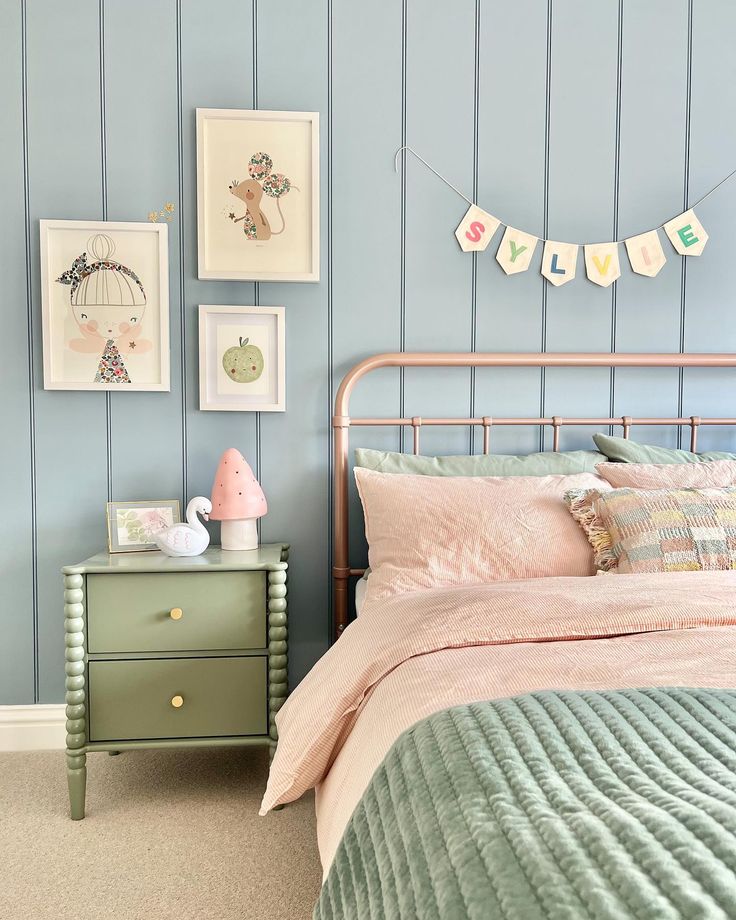 a bed room with a neatly made bed next to a night stand and pictures on the wall