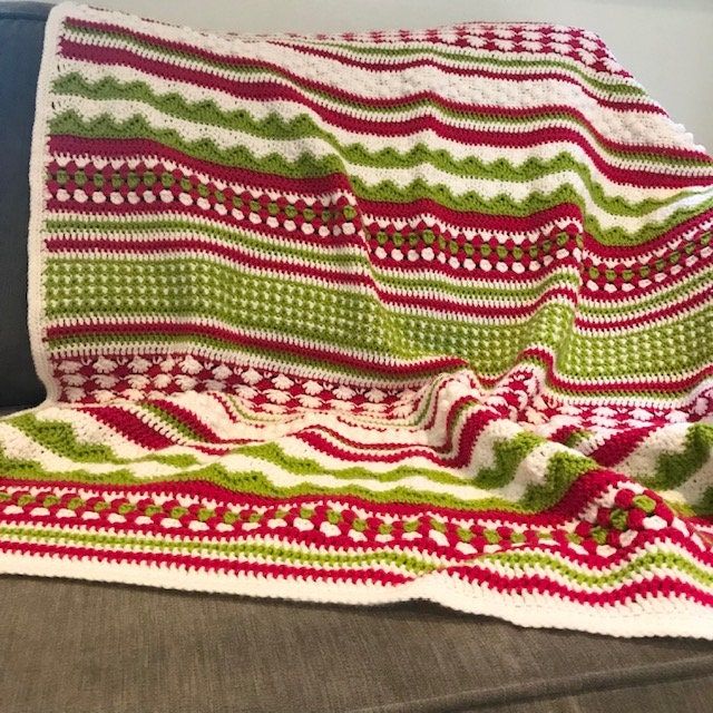 a crocheted blanket sitting on top of a couch