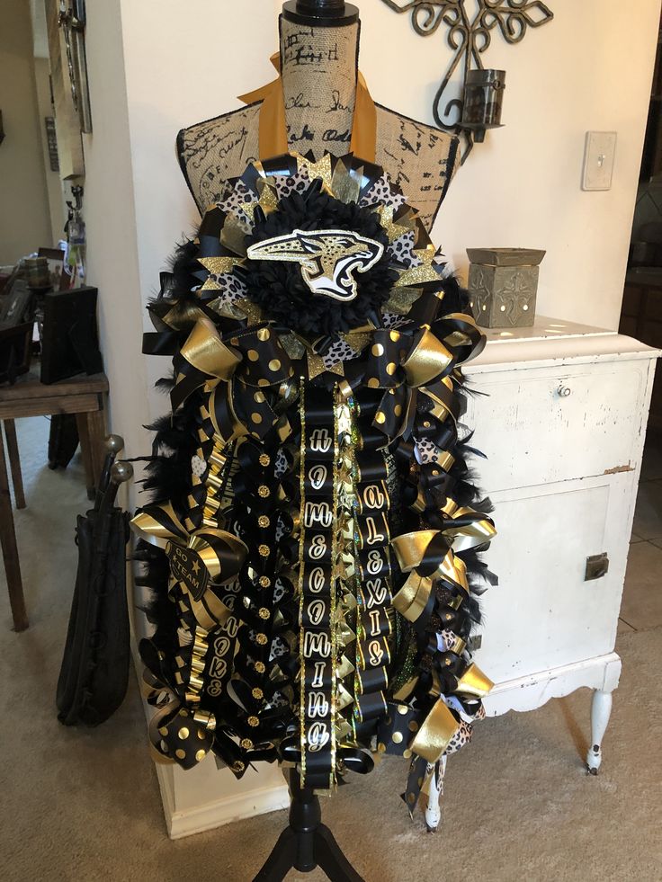 a mannequin dressed in black and gold ribbons