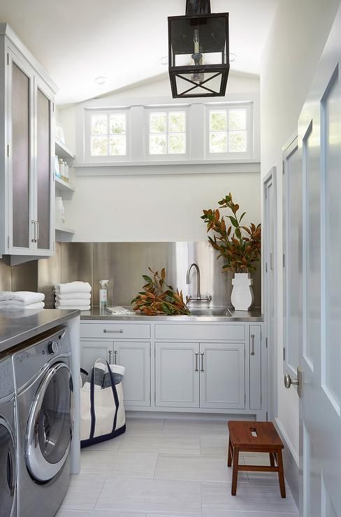 a washer and dryer in a small room with lots of cabinet space on the walls