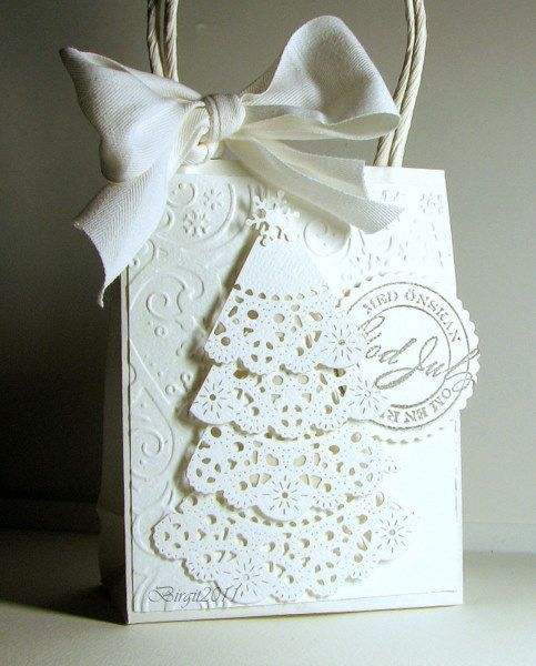 a white gift bag with a bow on it