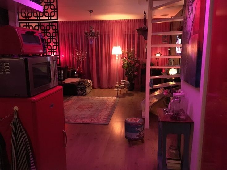 a living room filled with furniture and pink lighting