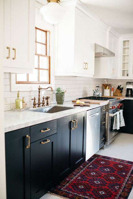 a kitchen with black cabinets and white walls