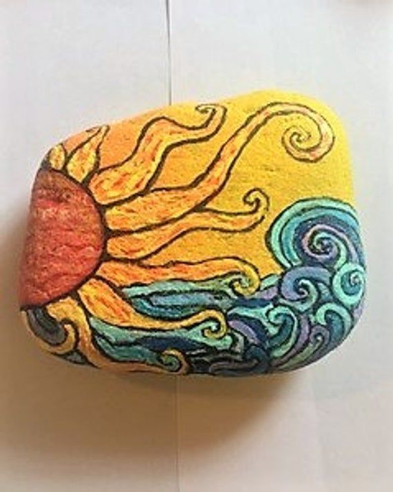 a painted rock with the sun on it