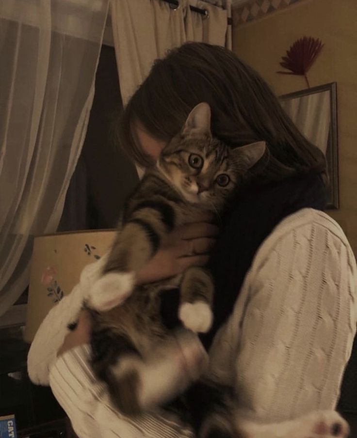 a woman holding a cat in her arms