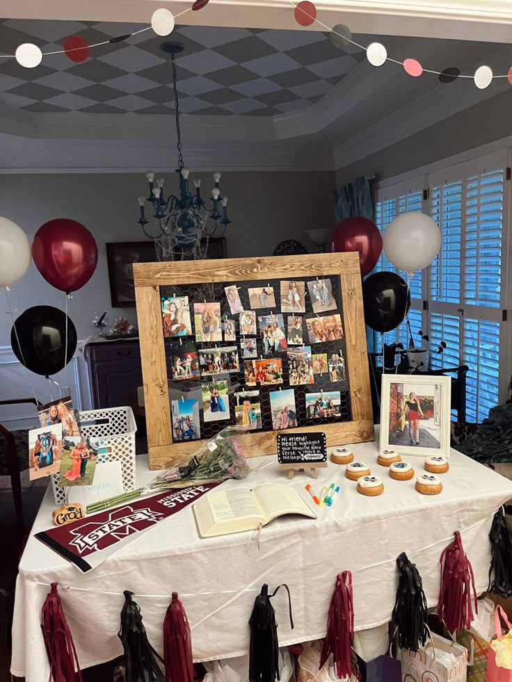 a table topped with pictures and cupcakes next to balloons