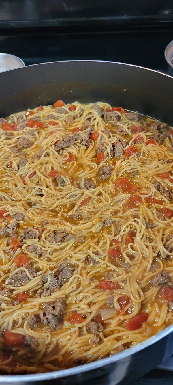 a large pan filled with spaghetti and meat