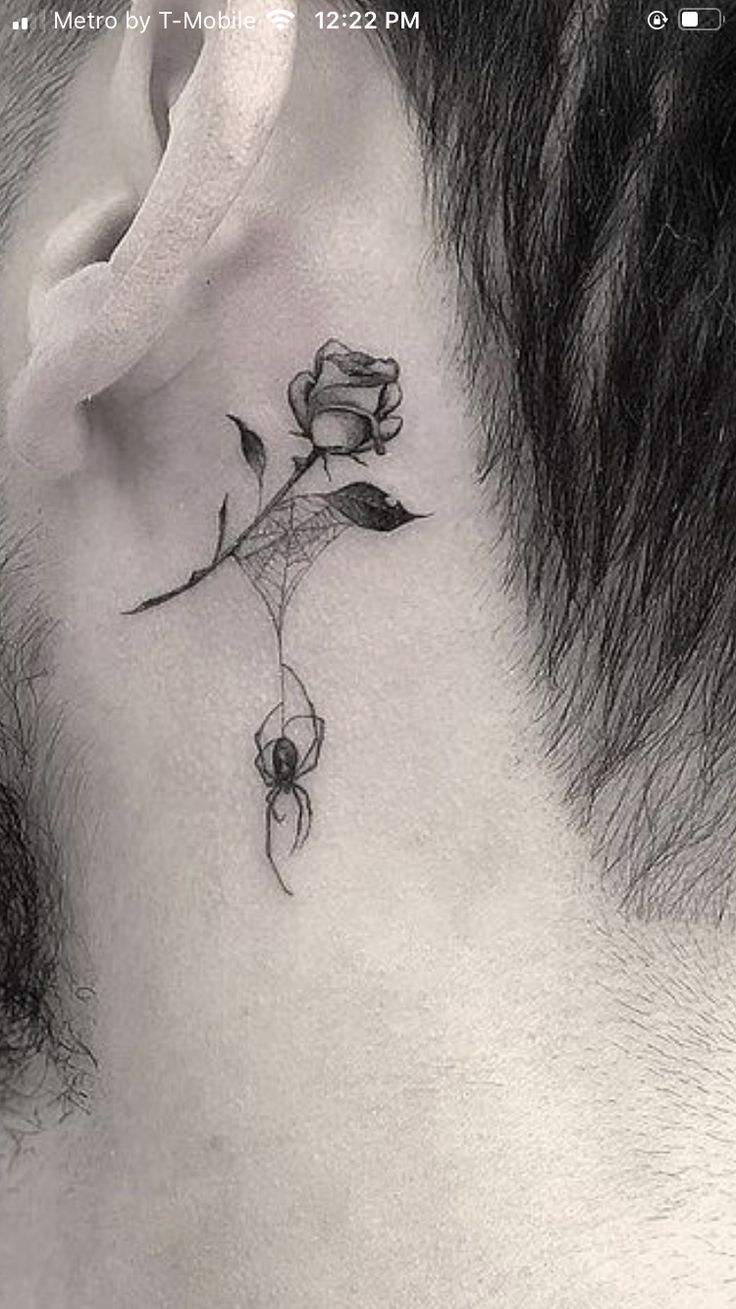 a man with a rose tattoo on his neck and behind the ear is a spider