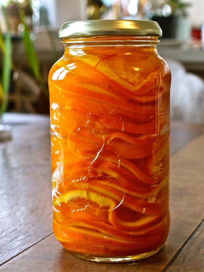 a jar filled with liquid sitting on top of a wooden table