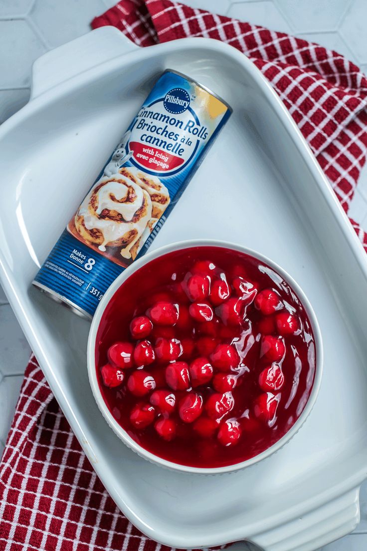 cranberry sauce and cinnamon rolls on a white serving platter with a red checkered napkin