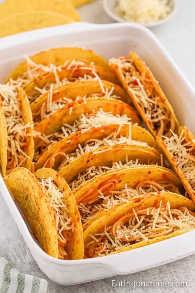 baked tortilla wedges with shredded cheese in a white dish on a table