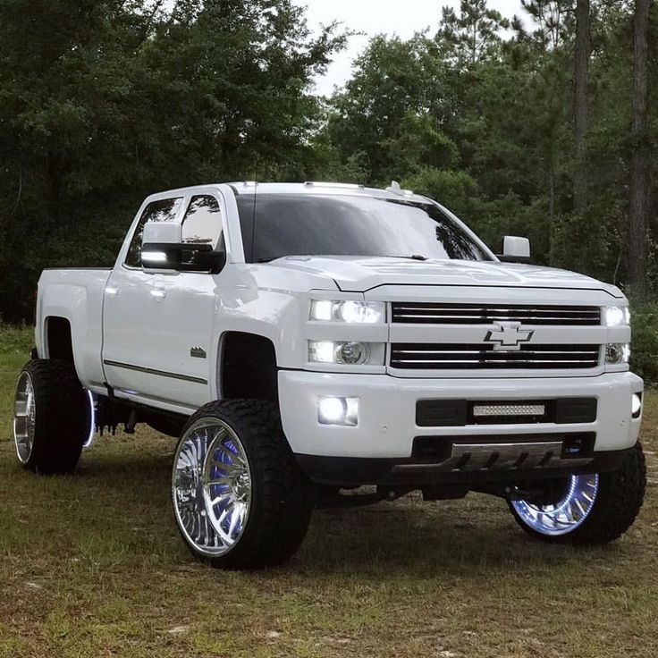 a white truck parked on top of a grass covered field