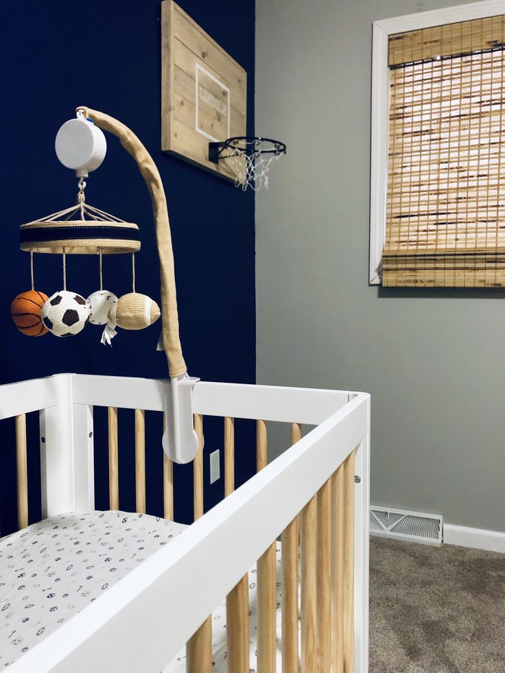 a baby's crib with a basketball hanging from it