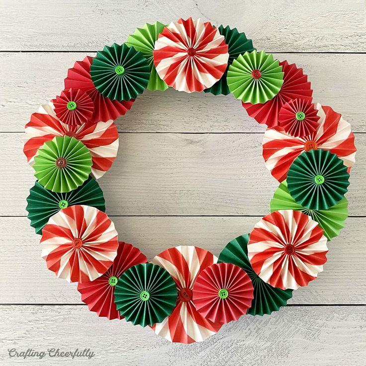 a wreath made out of green and red paper with candy canes in the middle