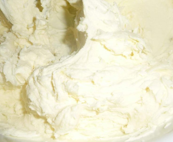 a white bowl filled with whipped cream on top of a table